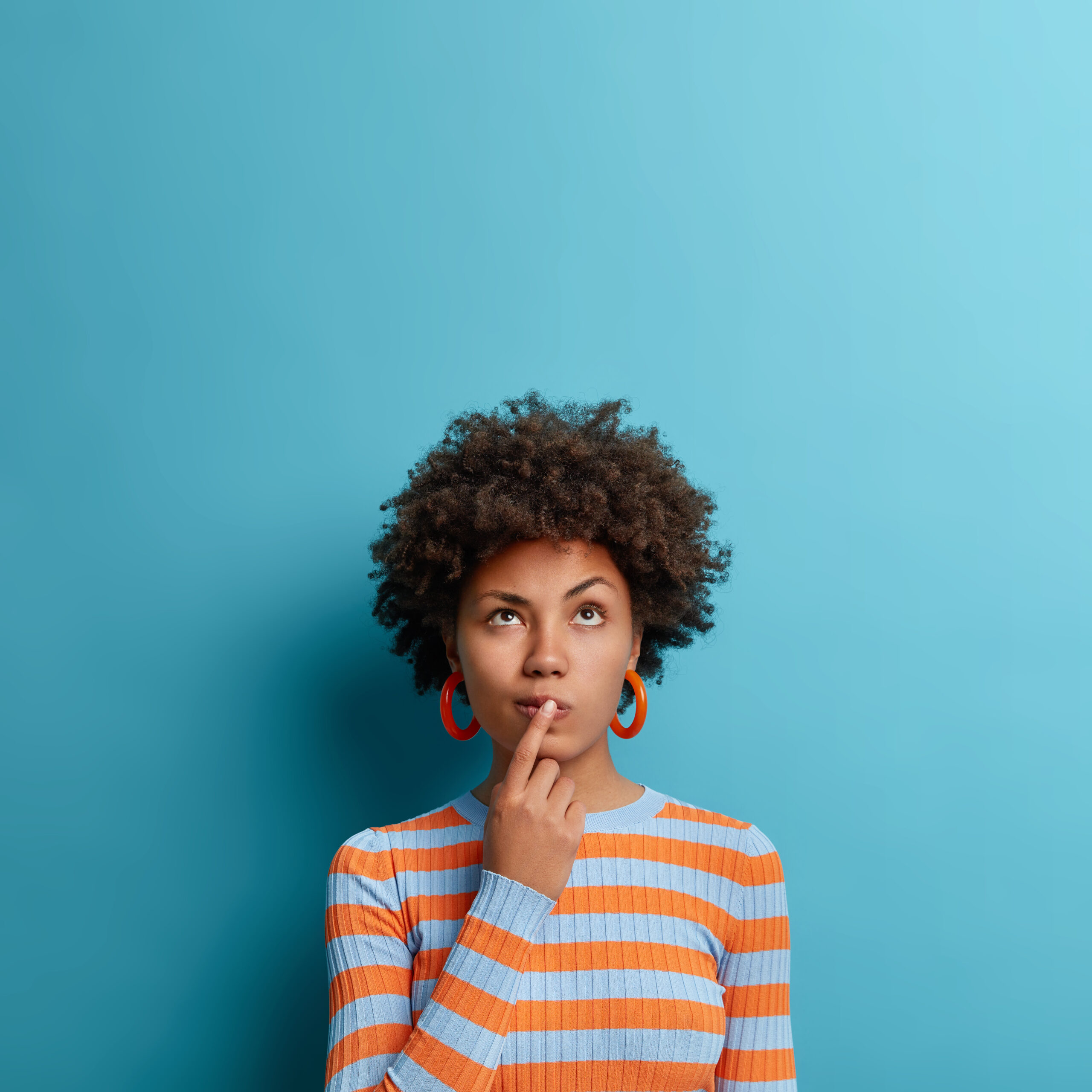 Woman thinking against a blue background