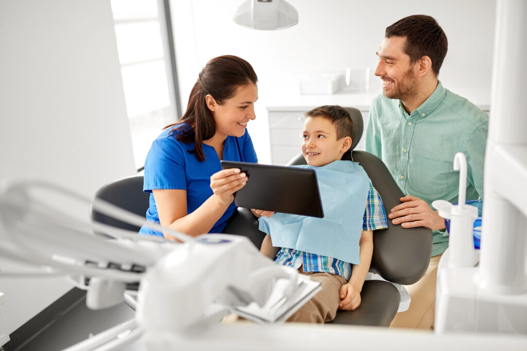 Dental professional discussing a visit with a child and parent